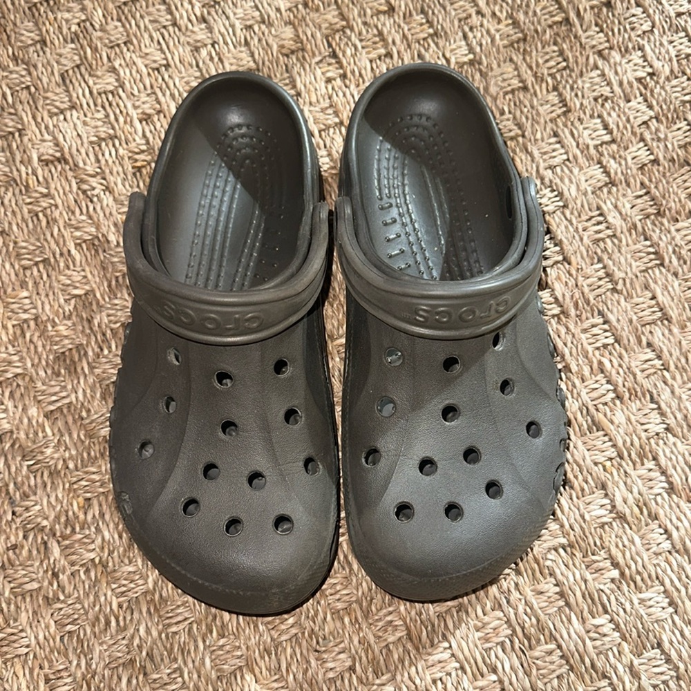 Brown/grayish women’s size 9 crocs/ men’s size 7 crocs.